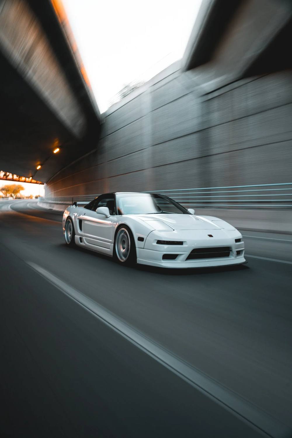 White Acura NSX rolling shot through an underpass
