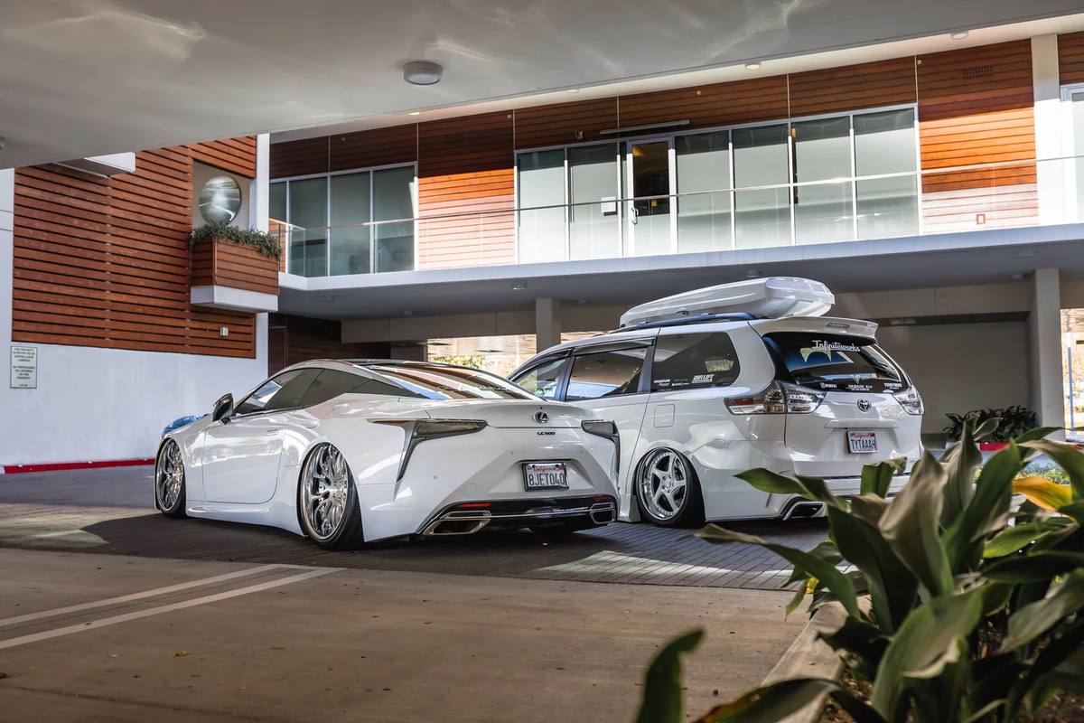 White coupe and hatchback outside a modern building