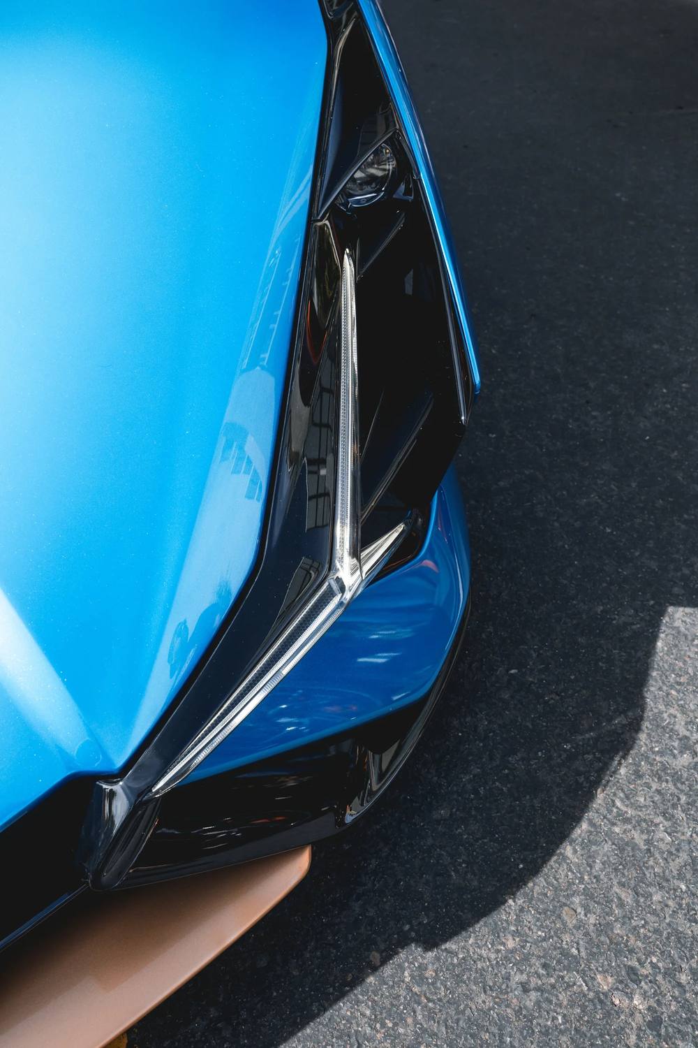 Blue supercar headlight close-up