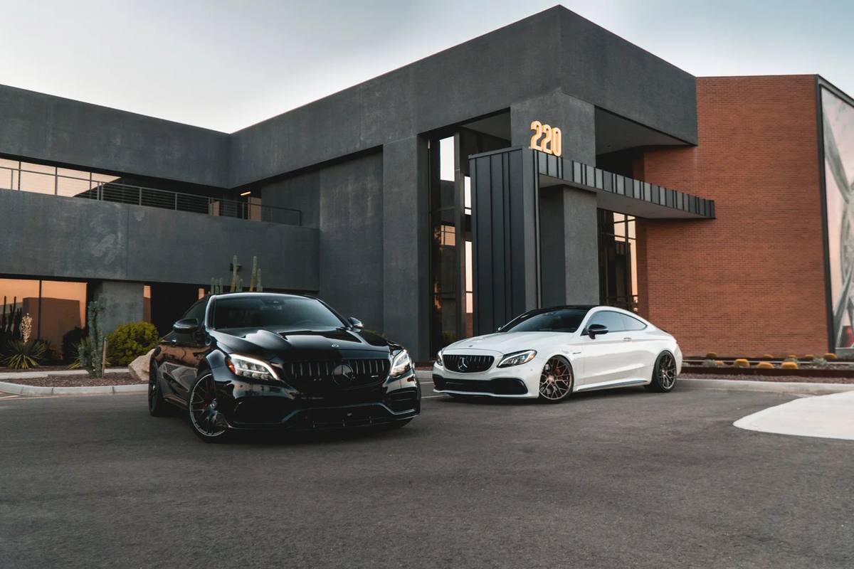 Black and white Mercedes coupes in front of a dark building