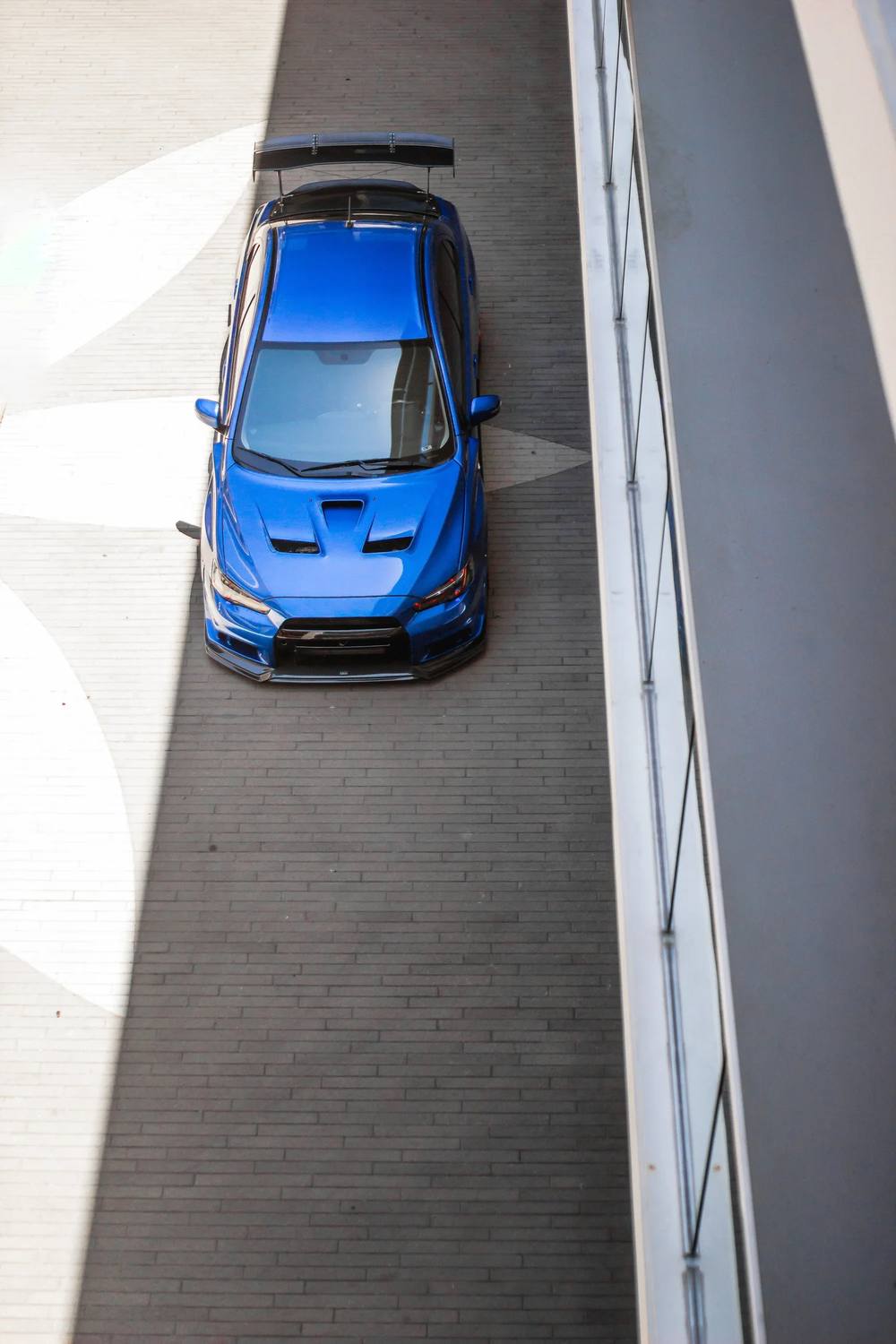 Overhead of a blue Subaru WRX beside a building